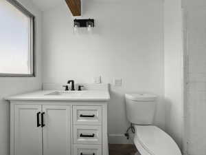Full bath with vanity and beam ceiling