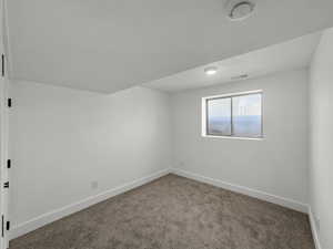 Unfurnished room with carpet and a smoke detector