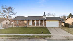 Ranch-style home featuring brick siding, a garage, a shingled roof, and covered porch