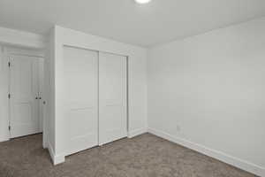 Unfurnished bedroom with carpet flooring and a closet