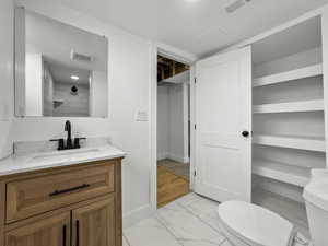 Full bath with light marble finish flooring and vanity