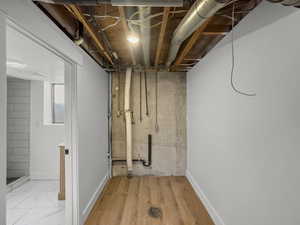 Basement with baseboards and light wood-style flooring