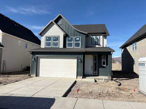 View of front of property featuring board and batten siding, a garage, concrete driveway, covered porch, and roof with shingles