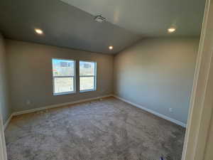 Unfurnished room featuring carpet flooring, lofted ceiling, and recessed lighting
