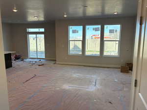 Unfurnished living room featuring baseboards