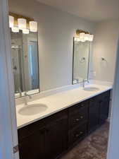 Full bath featuring double vanity and a stall shower