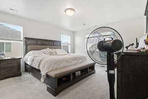 Master bedroom featuring light colored carpet