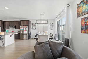 Dining area featuring light wood finished floors, recessed lighting, and a textured ceiling