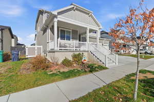 View of front of property featuring covered porch, a gate, board and batten siding, and a residential view