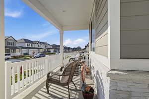 Covered porch featuring a residential view