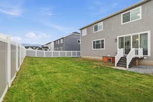 Back of house with a fenced backyard and stucco siding