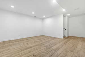 Basement with light wood-style flooring and recessed lighting