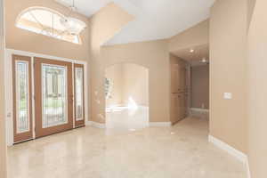 Foyer featuring arched walkways and vaulted ceiling