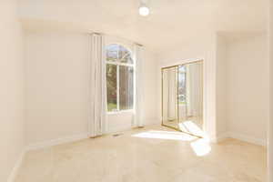 Spare room with baseboards and vaulted ceiling