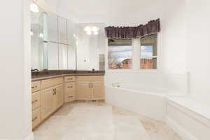 Full bathroom featuring double vanity and a bath