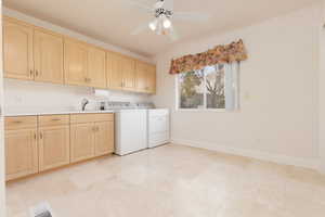 Laundry area featuring ceiling fan, cabinet space, and washer and clothes dryer
