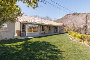 Back of property with stucco siding, a tiled roof, and a patio area