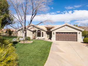 Mediterranean / spanish-style home with an attached garage, stucco siding, concrete driveway, a tile roof, and a front lawn