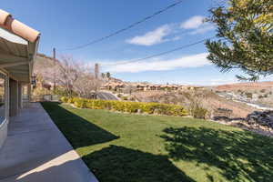 View of green lawn featuring a residential view and a patio