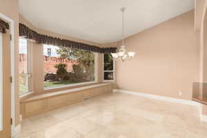 Unfurnished dining area with vaulted ceiling and a chandelier