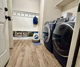 Laundry area with light wood-type flooring and separate washer and dryer