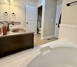 Full bath featuring double vanity and light tile patterned floors