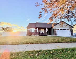 View of front of house featuring a porch, a garage, a front yard, and concrete driveway