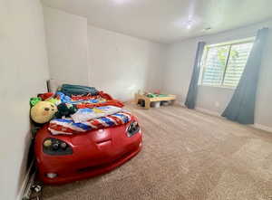 Bedroom featuring light colored carpet and a textured ceiling