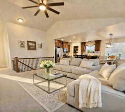 Carpeted living area with lofted ceiling and a ceiling fan