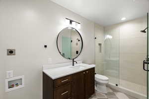 Bathroom with vanity, a stall shower, light floors, and recessed lighting