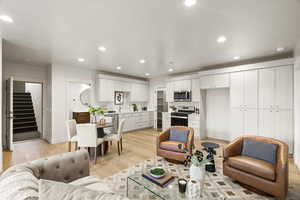 Living area with light wood-type flooring and recessed lighting