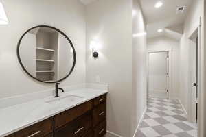 Bathroom featuring light flooring, vanity, and recessed lighting