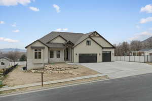Modern farmhouse with a mountain view, a shingled roof, board and batten siding, driveway, and a garage