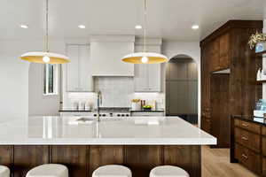 Kitchen with a kitchen bar, parquet floors, and dark stone countertops