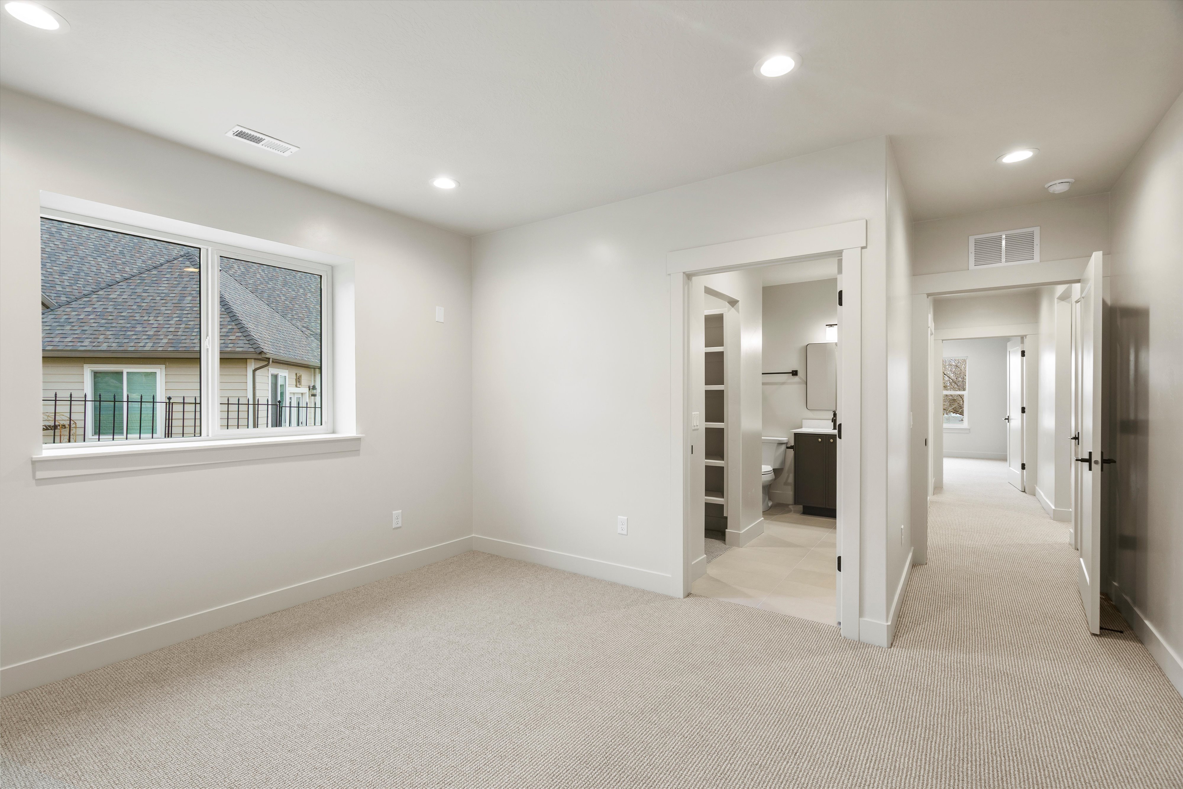 Unfurnished bedroom with light carpet, recessed lighting, and connected bathroom