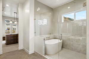 Bathroom with a shower stall, a soaking tub, and recessed lighting