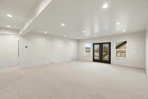 Empty room featuring light carpet, french doors, and recessed lighting