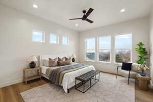 Bedroom with light wood-style floors, ceiling fan, and recessed lighting
