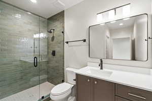 Bathroom with vanity, a stall shower, and recessed lighting