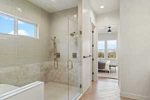 Ensuite bathroom with healthy amount of natural light, a stall shower, recessed lighting, a ceiling fan, and light wood finished floors