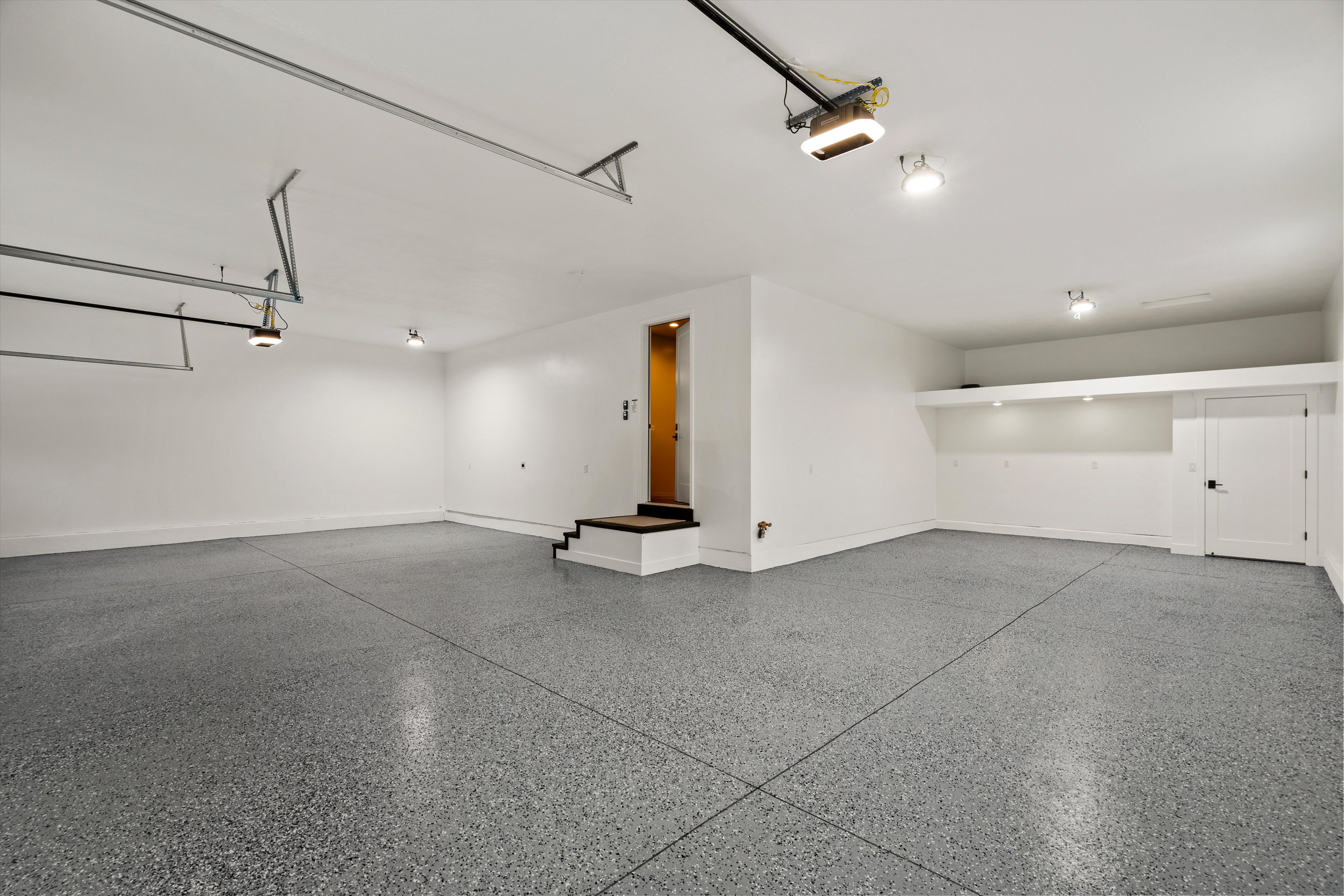 Garage with baseboards and a garage door opener