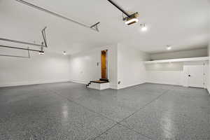 Garage with baseboards and a garage door opener