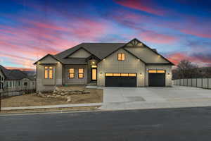 Modern inspired farmhouse featuring board and batten siding, a shingled roof, concrete driveway, an attached garage, and stone siding