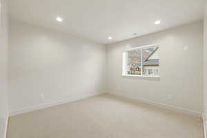 Spare room featuring light carpet and recessed lighting