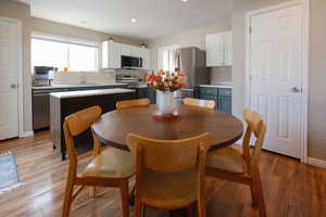 Dining room with healthy amount of natural light, light wood-style floors, and recessed lighting