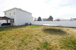 Fenced backyard featuring a patio, a trampoline, and a gazebo
