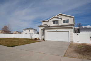 Traditional home featuring a gate, concrete driveway, and an attached garage