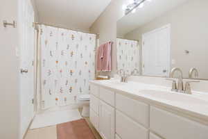 Bathroom with double vanity and shower / bath combination with curtain