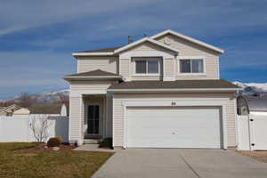 View of front of house featuring a mountain view, a gate, driveway, roof with shingles, and an attached garage