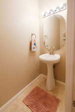 Bathroom with light tile patterned floors and baseboards